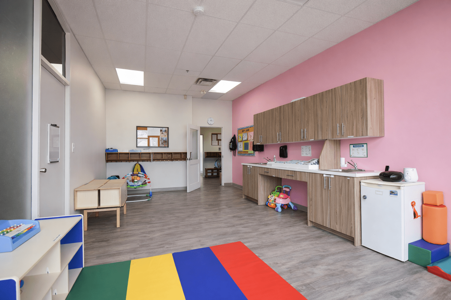 Infant daycare room with soft play flooring, custom cabinetry, handwashing station, and child-safe finishes designed to meet Ontario childcare licensing requirements