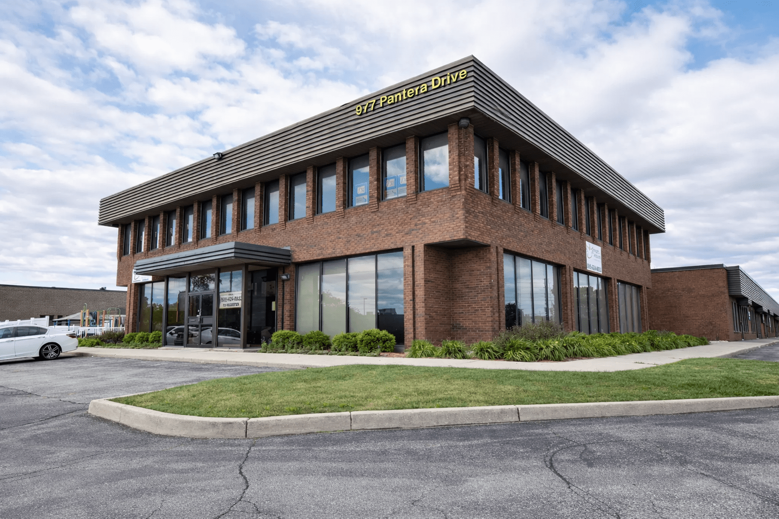 Two-storey commercial daycare facility exterior with brick façade, aluminum glazing, and professional site layout at 977 Pantera Drive, Mississauga