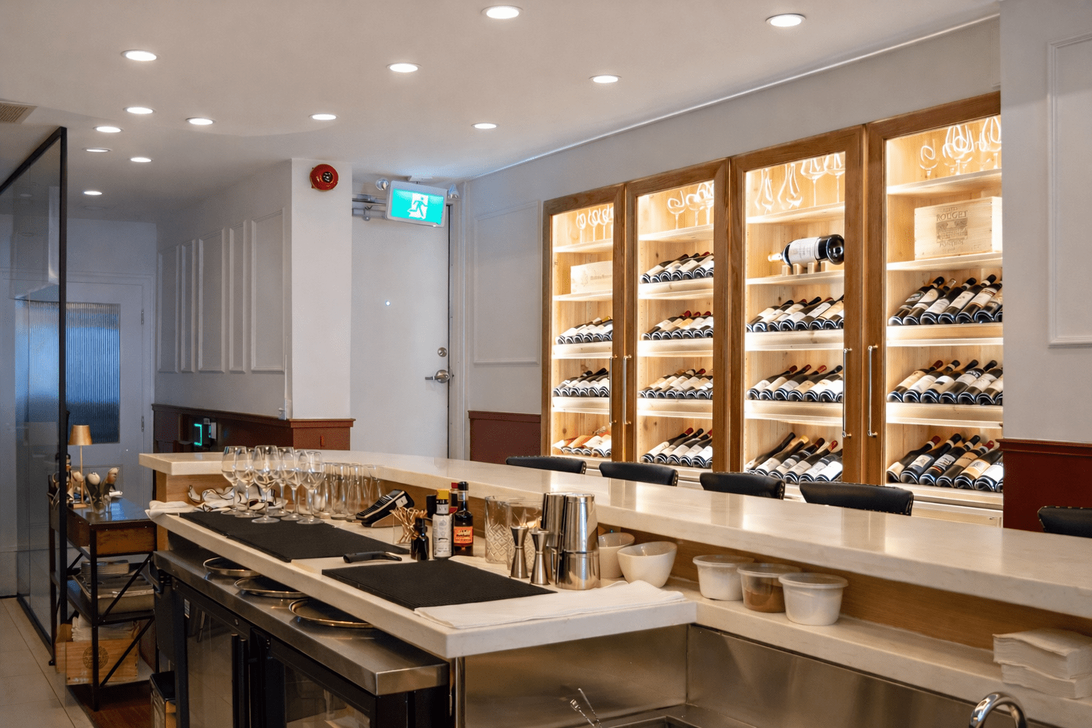 Luxury restaurant interior with custom wood paneling, marble tables, wine storage displays, and warm ambient lighting built by a Toronto commercial contractor