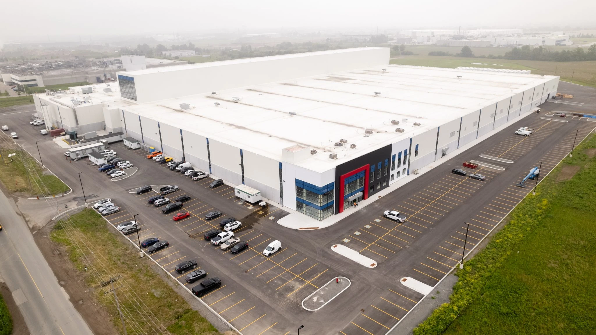 Side angle image of Atlantic Packaging’s extensive facility, emphasizing the strategic layout of parking spaces, loading docks, and a streamlined industrial building structure.