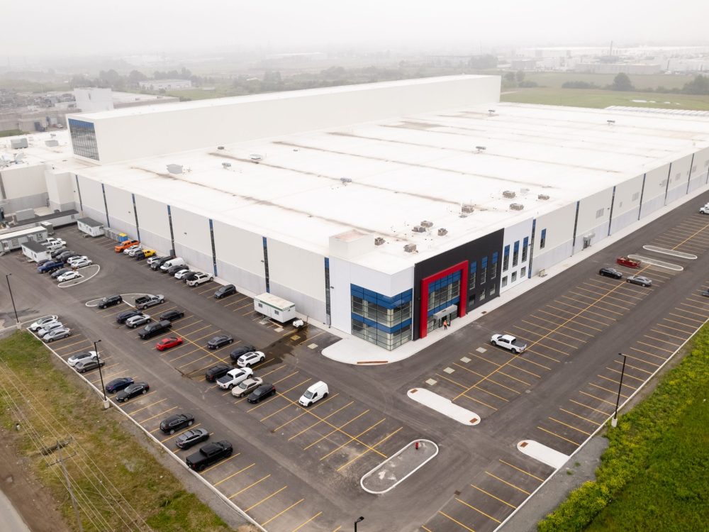 Side angle image of Atlantic Packaging’s extensive facility, emphasizing the strategic layout of parking spaces, loading docks, and a streamlined industrial building structure.