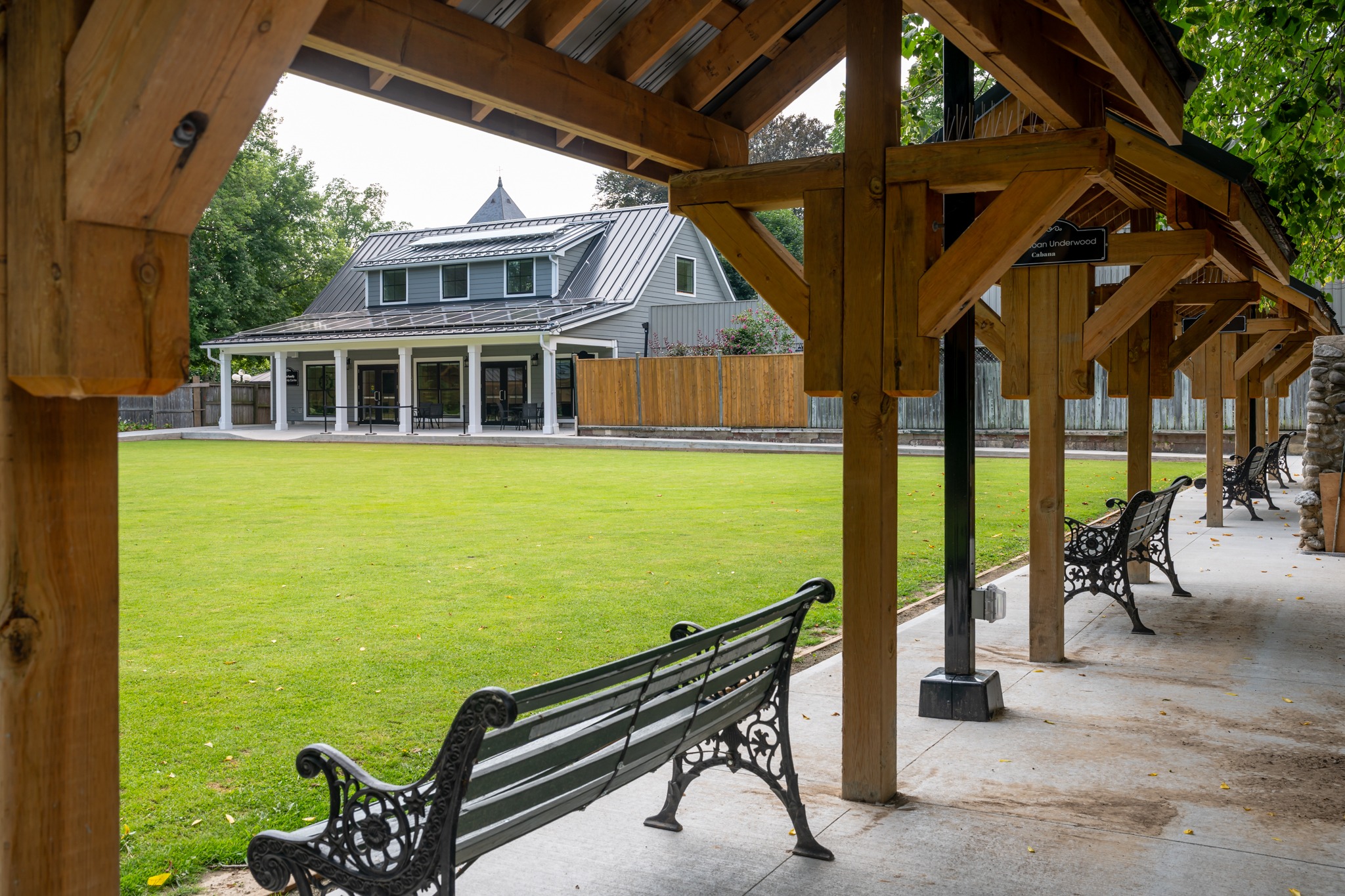 Wilkin Family Community Centre in Paris, Ontario, constructed by GTA General Contractors. The modern net-zero building features solar panels on a pitched roof, a covered patio with seating, landscaped parking, and a large green lawn, blending sustainability with community use.