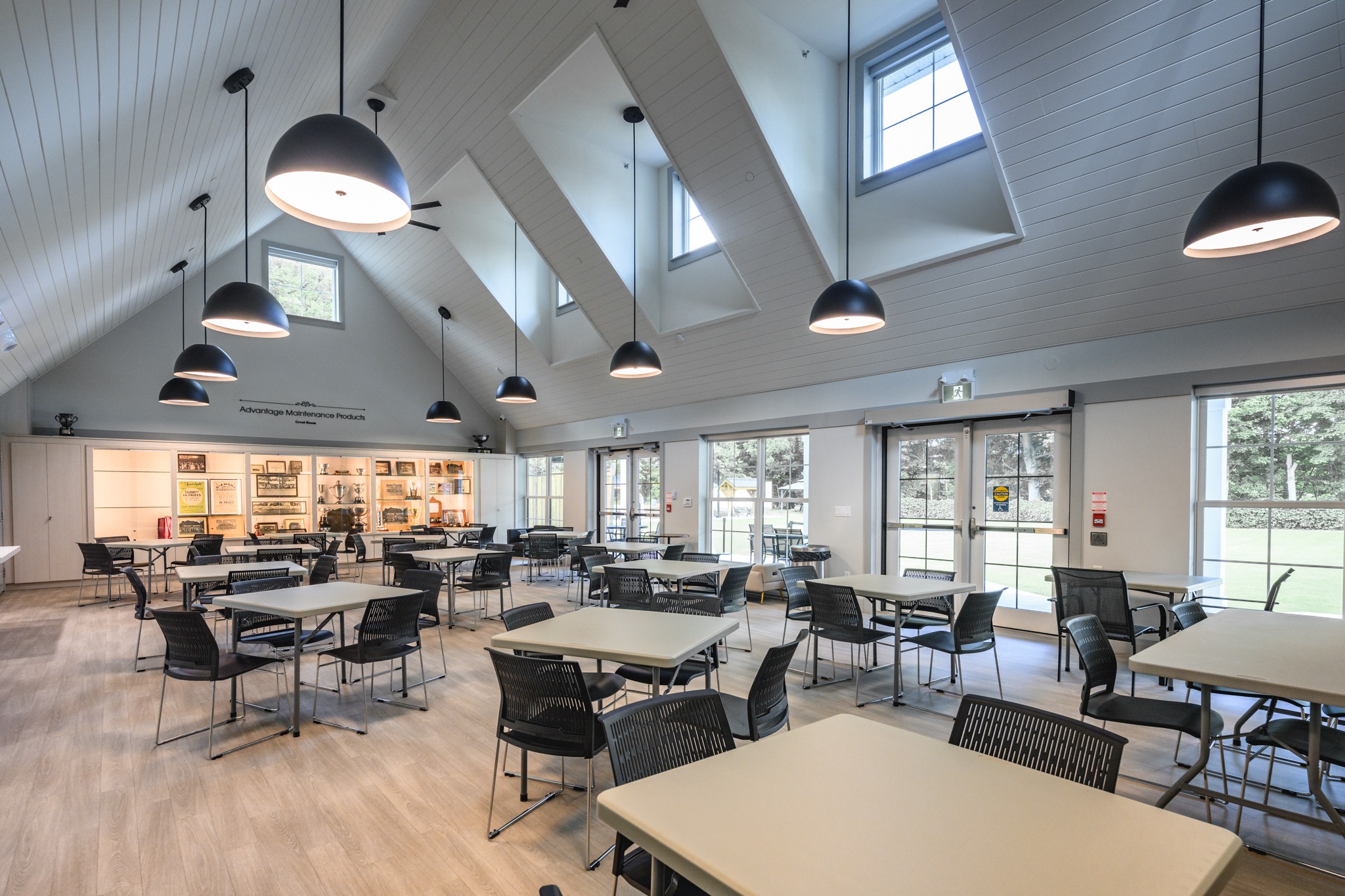 Wilkin Family Community Centre in Paris, Ontario, constructed by GTA General Contractors. The modern net-zero building features solar panels on a pitched roof, a covered patio with seating, landscaped parking, and a large green lawn, blending sustainability with community use.
