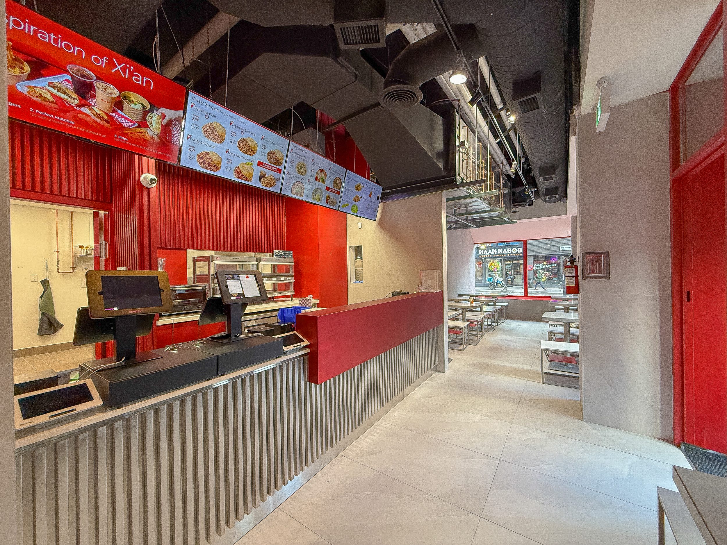 Interior restaurant design for Bingz Burger featuring custom banquette seating, red window framing, and clean minimalist finishes