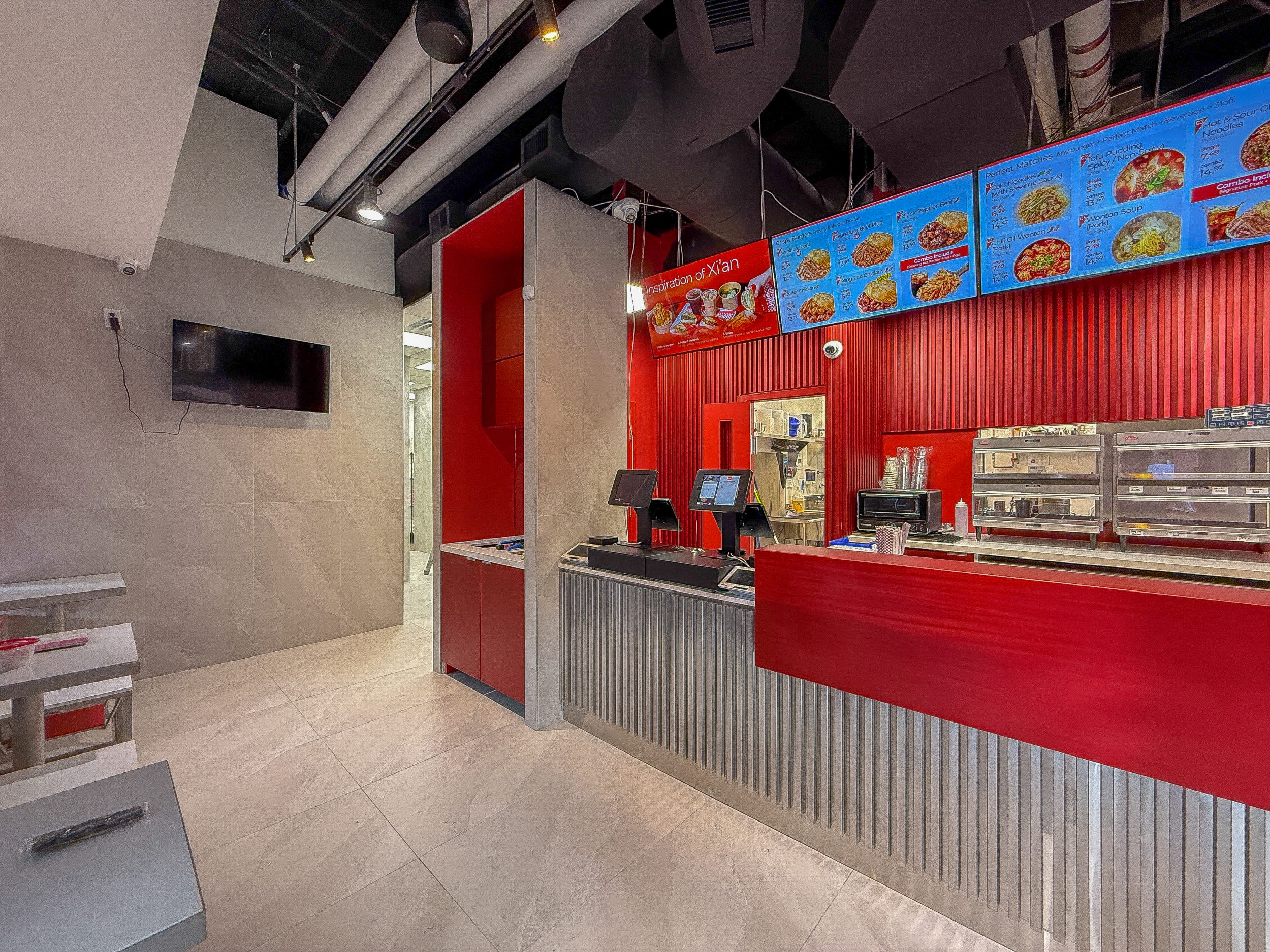 Restaurant construction interior for Bingz Burger Toronto featuring modern seating layout, custom tables, and red accent design.