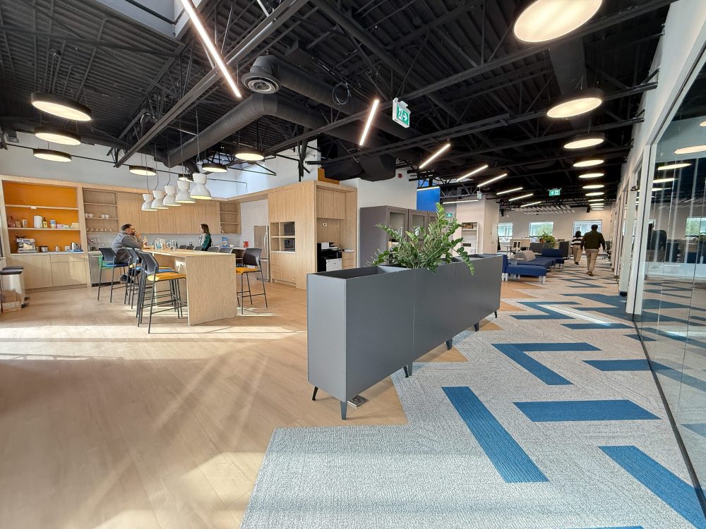 Commercial office fit-out for Neoen Toronto with modern layout, breakout seating, planter dividers, and open-concept work environment