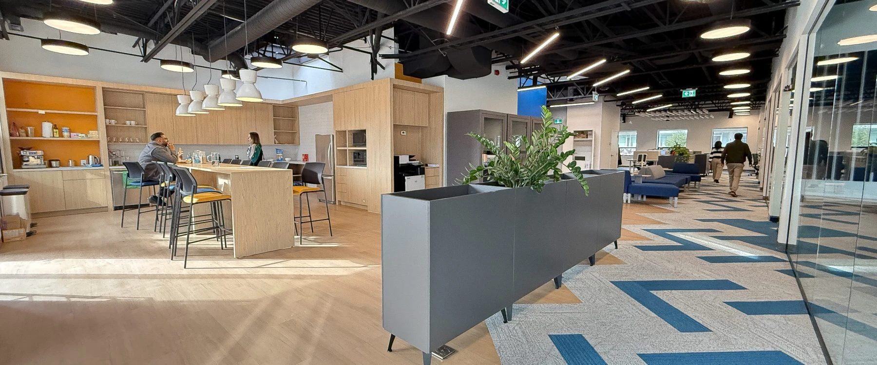 Commercial office fit-out for Neoen Toronto with modern layout, breakout seating, planter dividers, and open-concept work environment