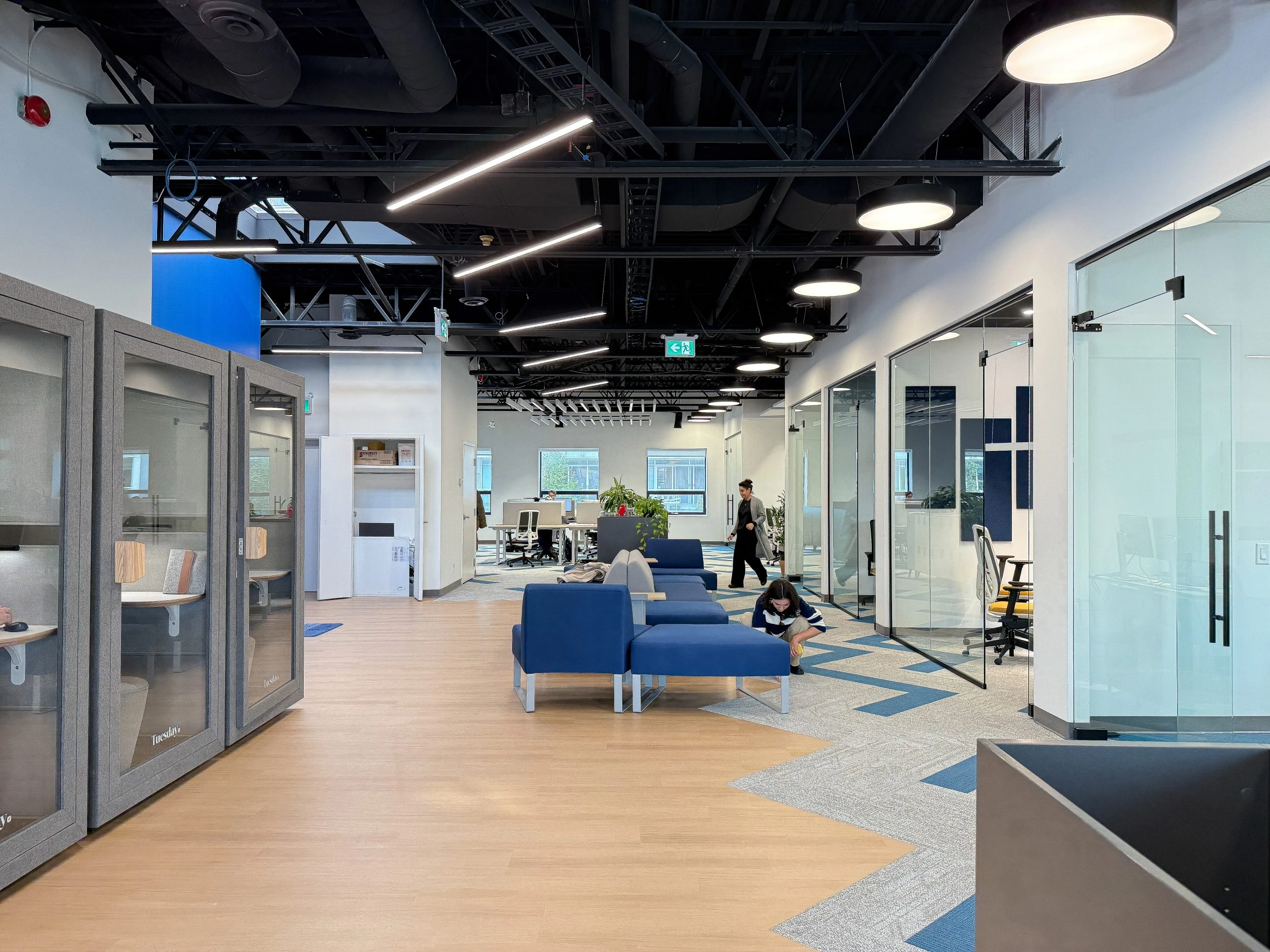 Modern office design-build project for Neoen Canada with exposed ceilings, acoustic lighting, and custom workstation configuration