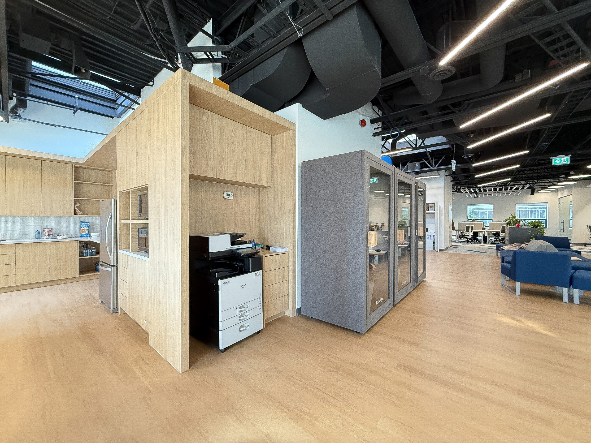 Modern office design-build project for Neoen Canada with exposed ceilings, acoustic lighting, and custom workstation configuration