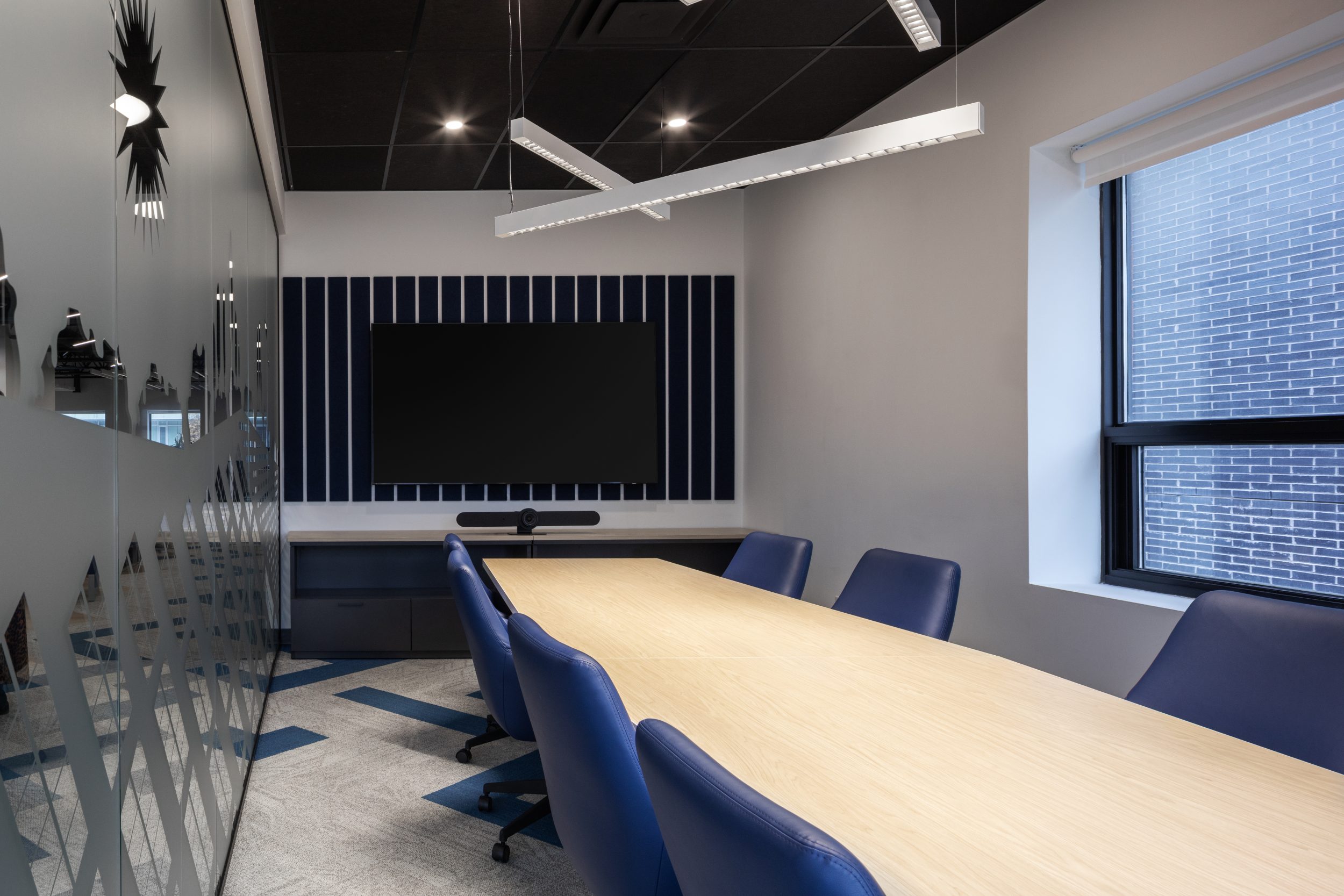 Neoen office construction showcasing modern boardroom with glass walls, conference table, and integrated AV setup