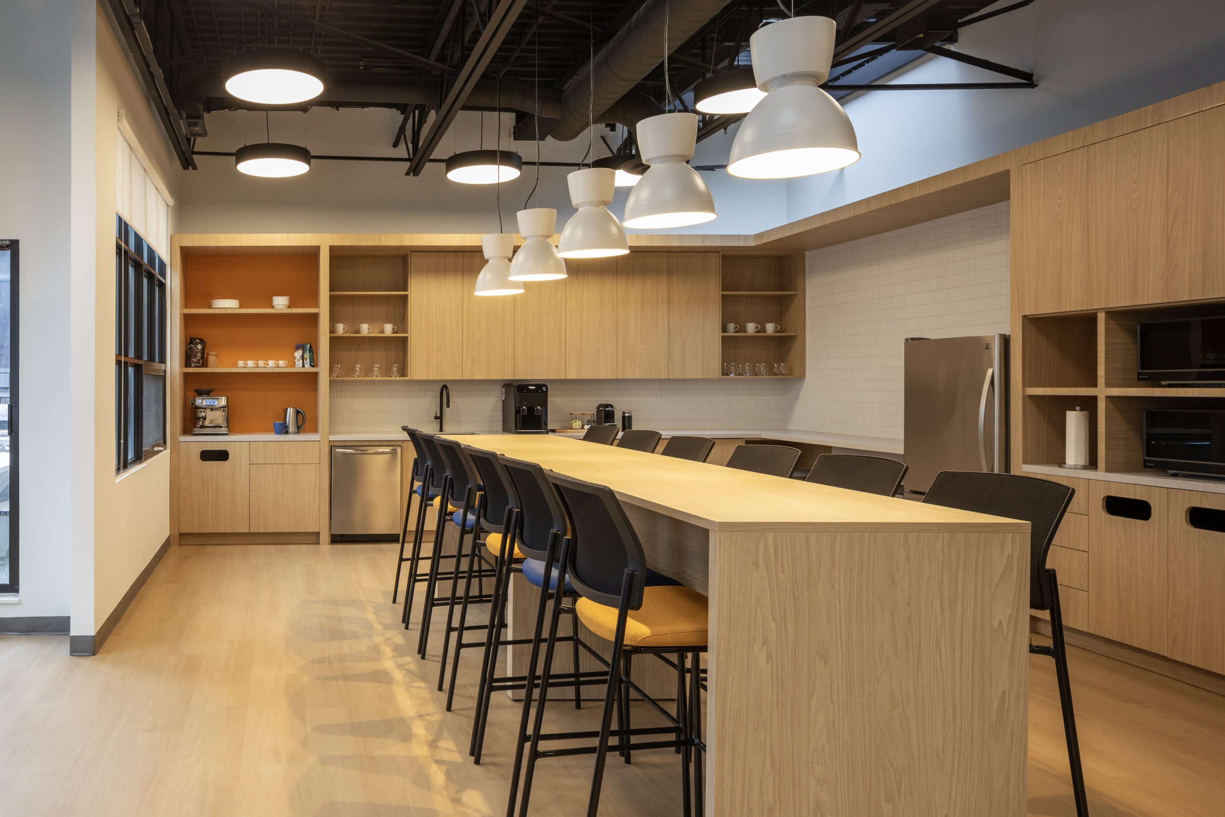 Neoen corporate office construction featuring large kitchen island, pendant lighting, custom cabinetry, and modern office interior design