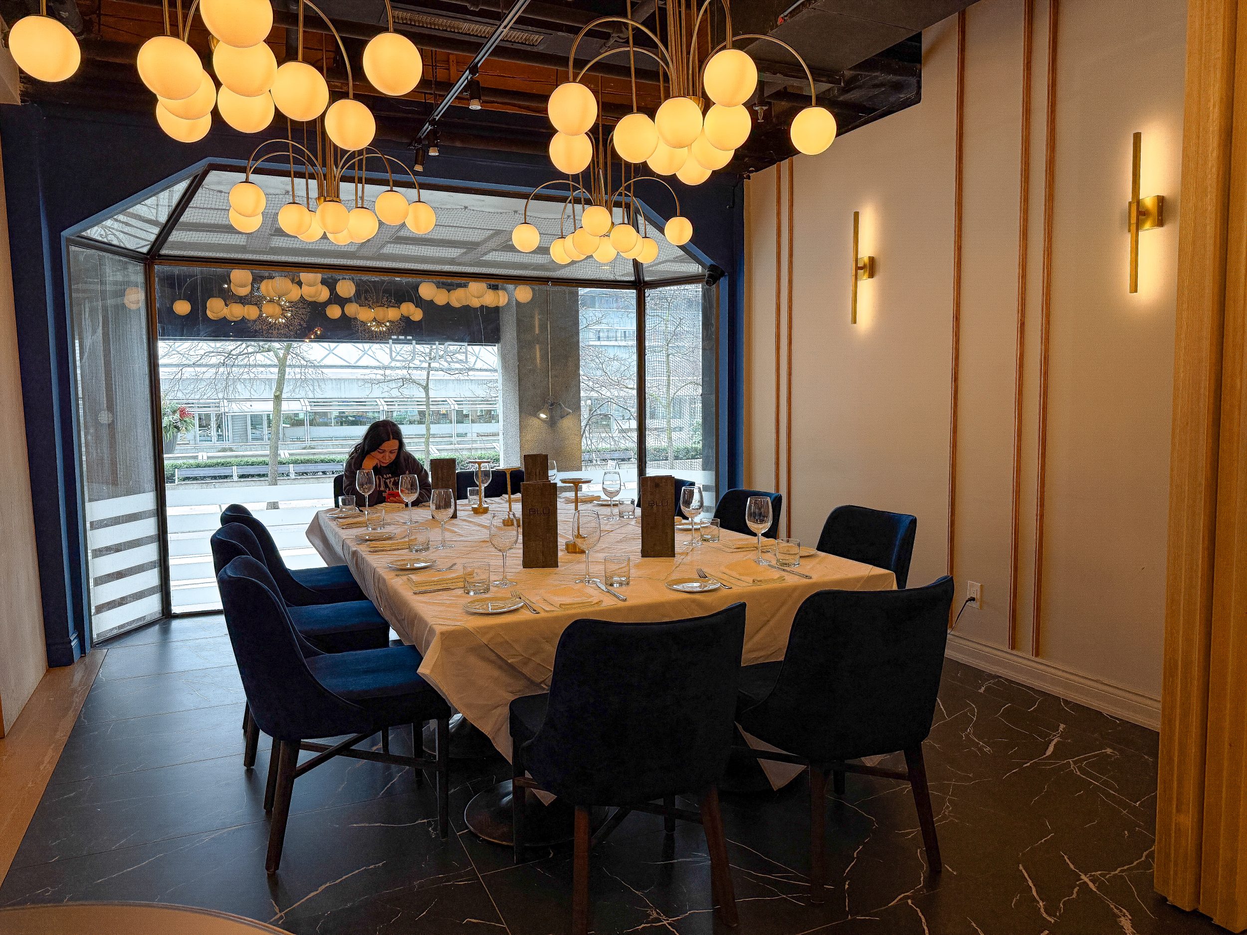 Private dining room at BLU Ristorante Toronto featuring custom lighting fixtures, upholstered chairs, and an intimate fine dining atmosphere.