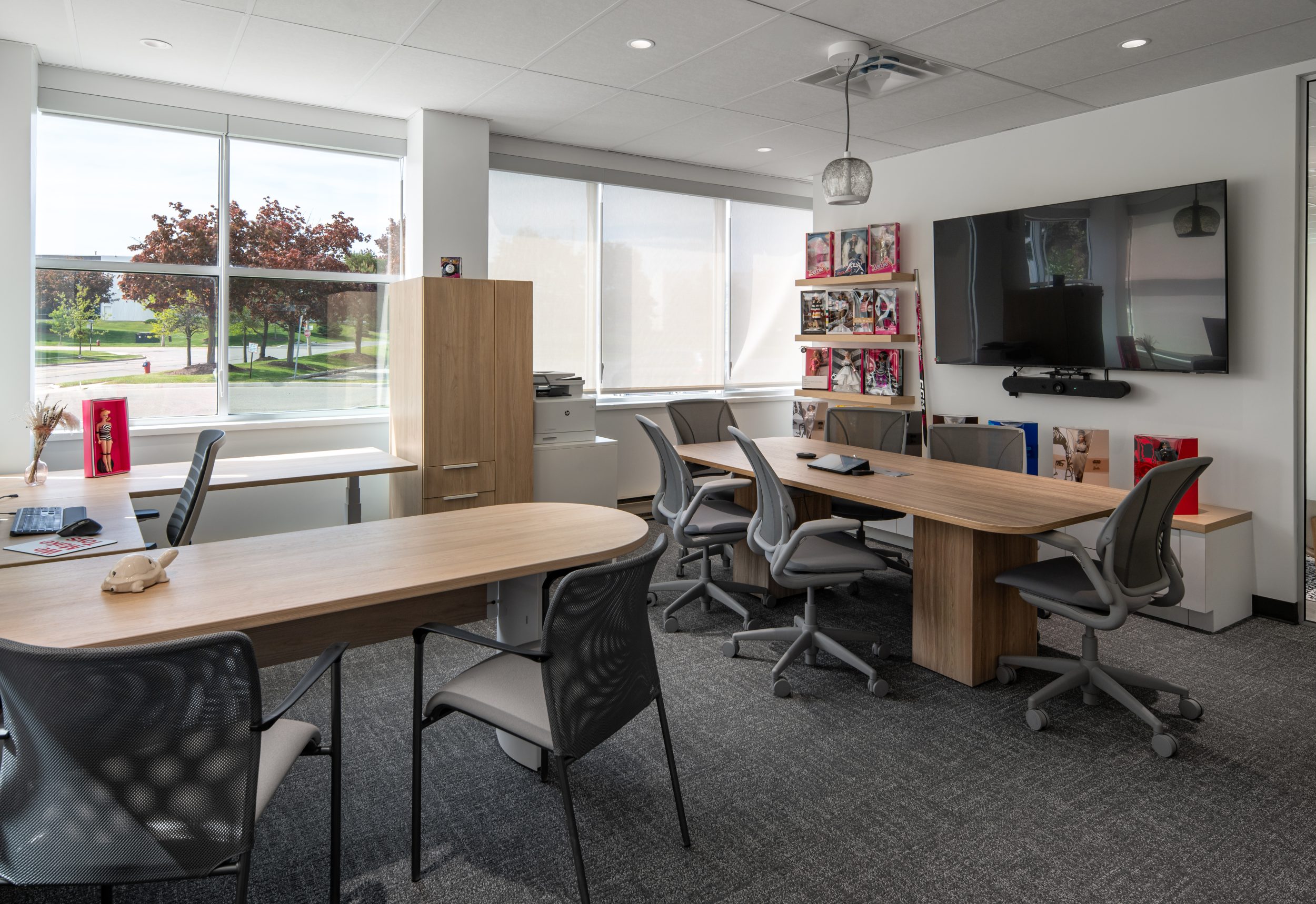 Private executive office at Mattel Canada Headquarters in Mississauga, Ontario, featuring a collaborative meeting area, custom cabinetry, product display shelving, natural lighting, premium finishes, and a modern commercial office renovation delivered through a Design-Build approach.