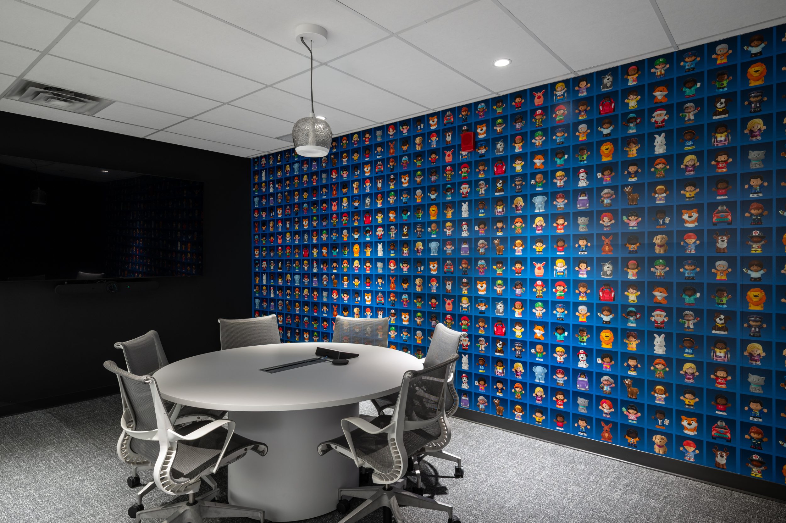 Contemporary meeting room at Mattel Canada Headquarters featuring custom character wall graphics, collaborative workspace design, integrated technology, and modern office furnishings as part of a Design-Build office renovation in Mississauga, Ontario.