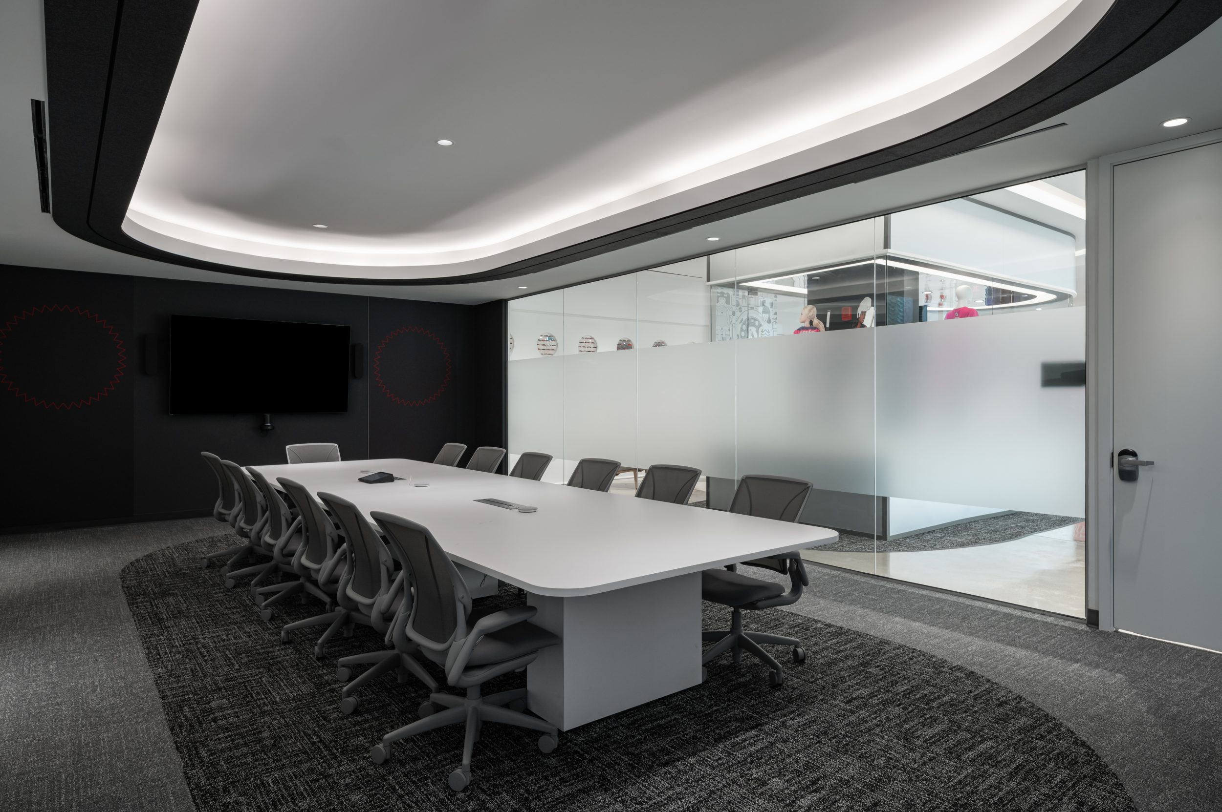 Executive boardroom at Mattel Canada Headquarters in Mississauga, Ontario featuring a custom conference table, floor-to-ceiling glass walls, integrated audiovisual technology, architectural ceiling lighting, premium corporate interiors, and modern workplace design completed by GTA General Contractors through a Design-Build commercial office renovation.
