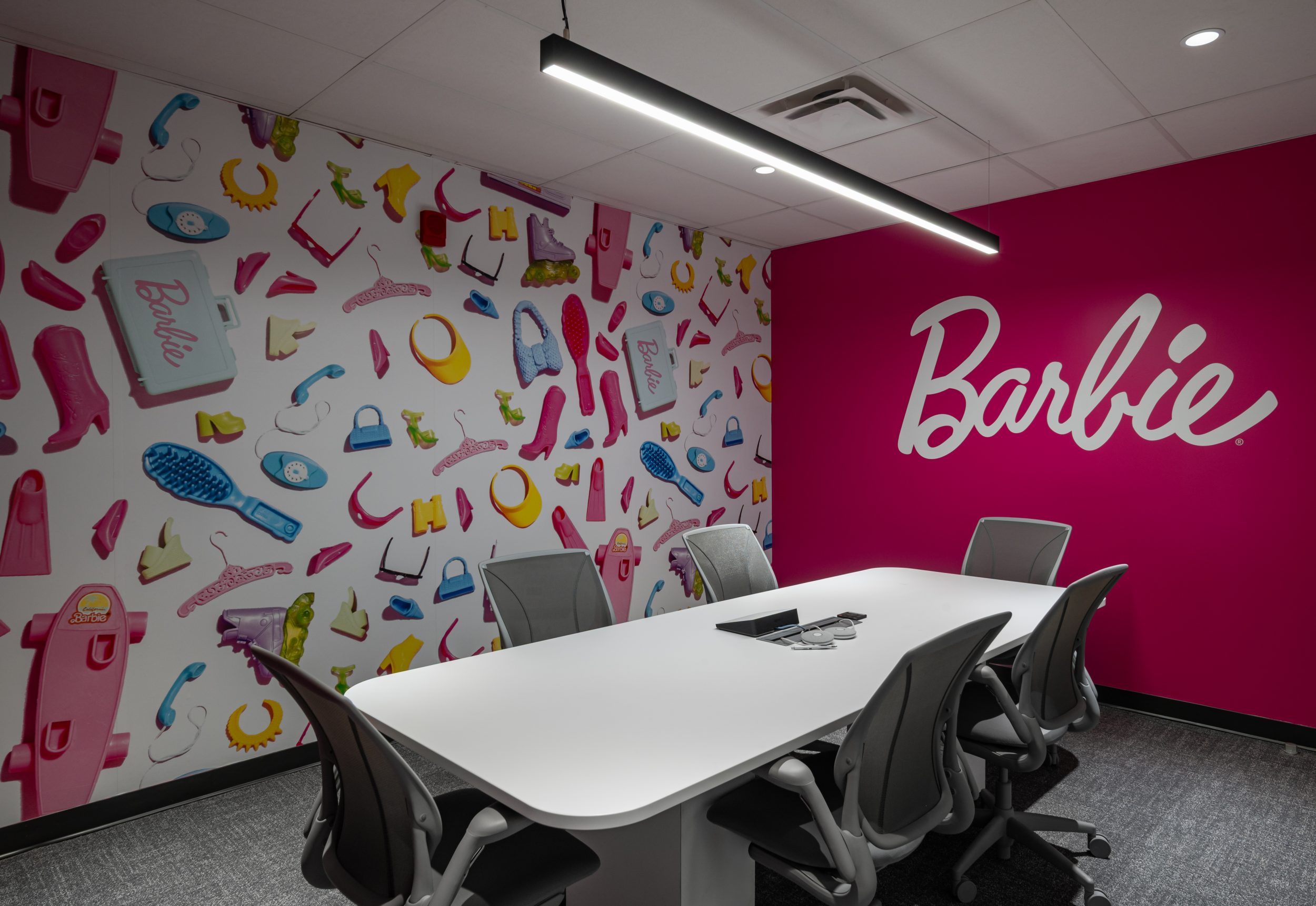 Barbie themed conference room at Mattel Canada Headquarters in Mississauga, Ontario, featuring custom Barbie wall graphics, branded feature wall, modern conference table, ergonomic seating, architectural lighting, collaborative meeting space, commercial office interior design, workplace branding, and Design-Build office renovation completed by GTA General Contractors.