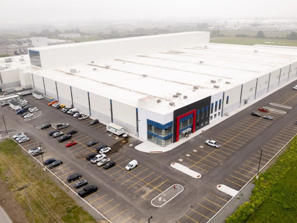 Side angle image of Atlantic Packaging’s extensive facility, emphasizing the strategic layout of parking spaces, loading docks, and a streamlined industrial building structure.