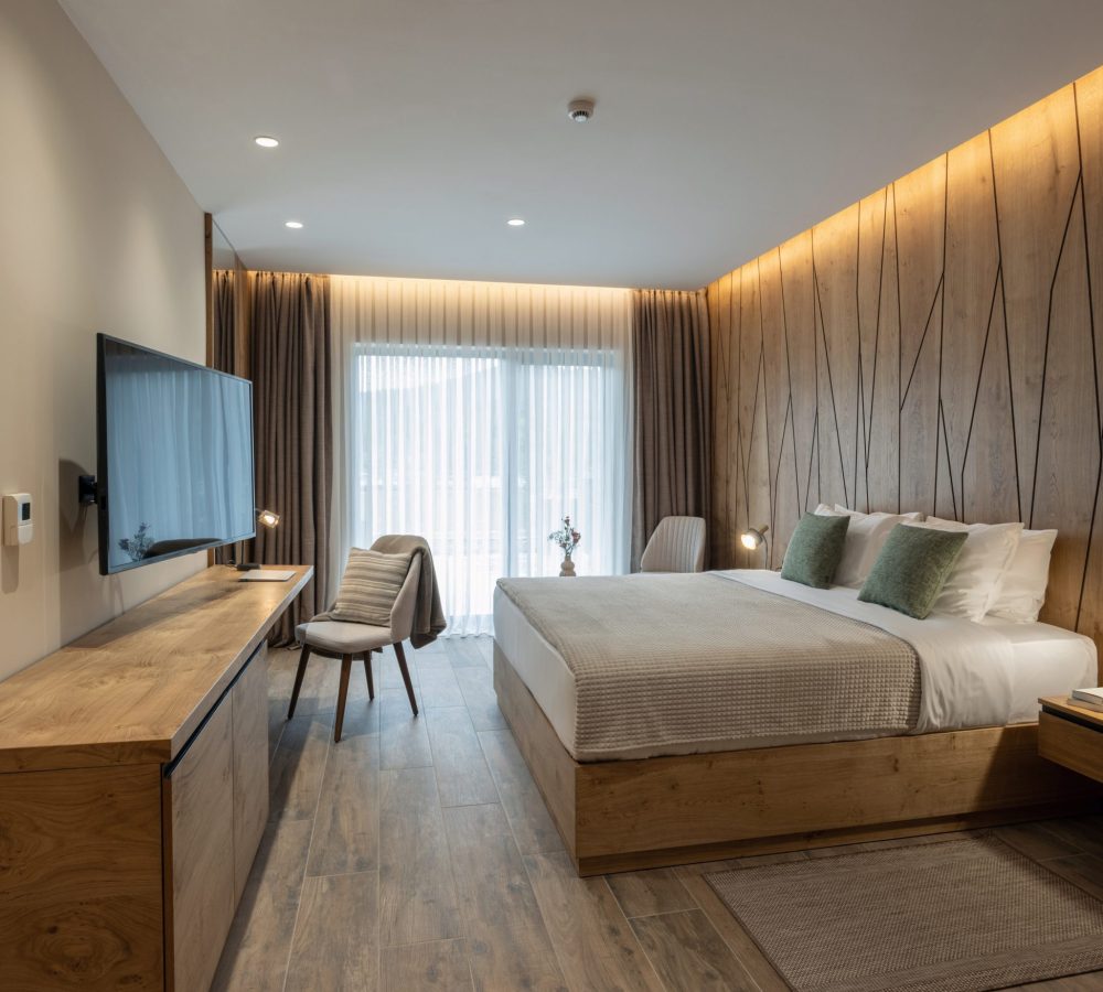 Modern boutique hotel guest room featuring custom wood wall panels, built-in furniture, and soft ambient lighting designed for a warm, inviting guest experience.